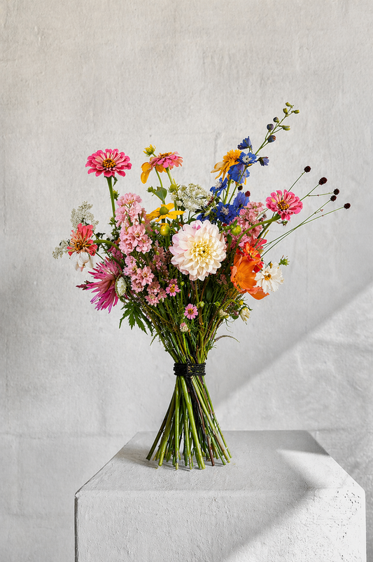 Luxe duurzaam boeket maat Medium in een licht interieur, een perfecte stijlindicatie van hoogwaardige seizoensbloemen van Raw & Pure.
